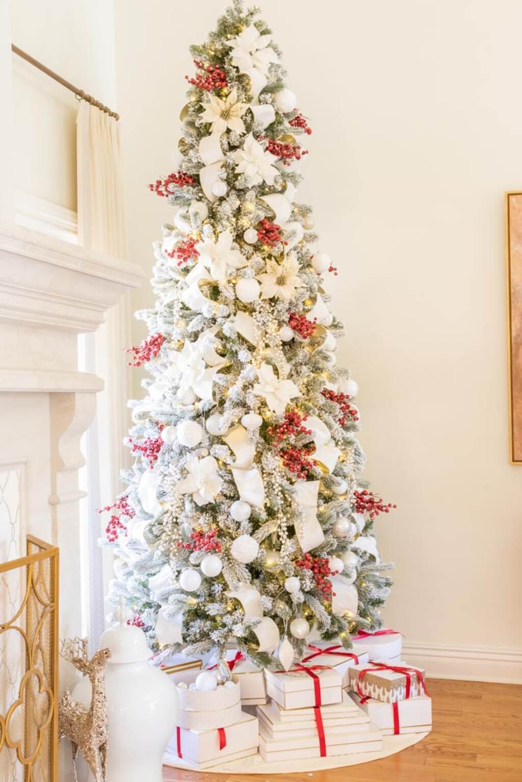 A white christmas tree with presents under it

