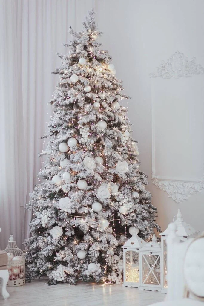 A white christmas tree in a white room
