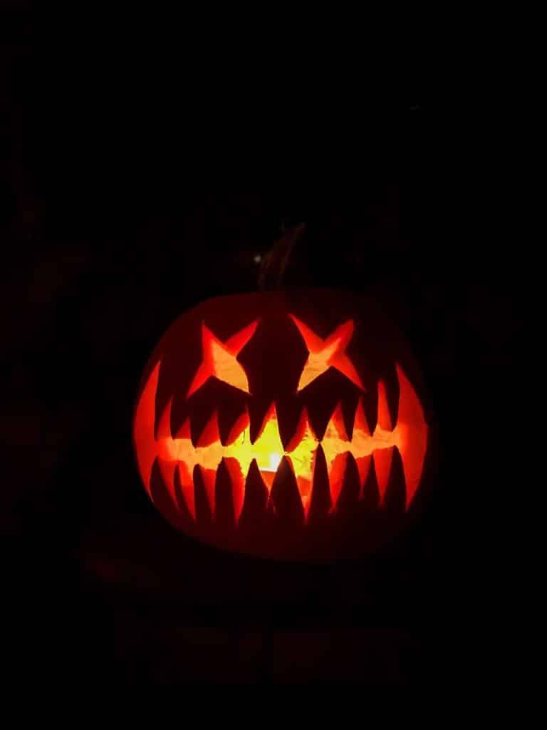 A pumpkin carved to look like a scary face
