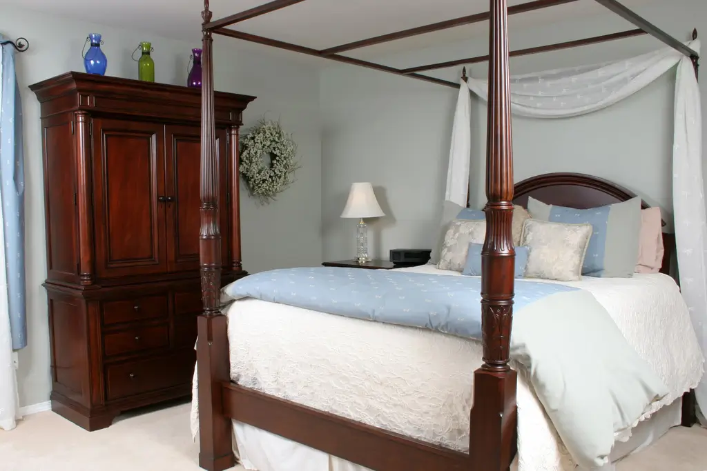 A bedroom with a bed, nightstands, and two pictures on the wall
