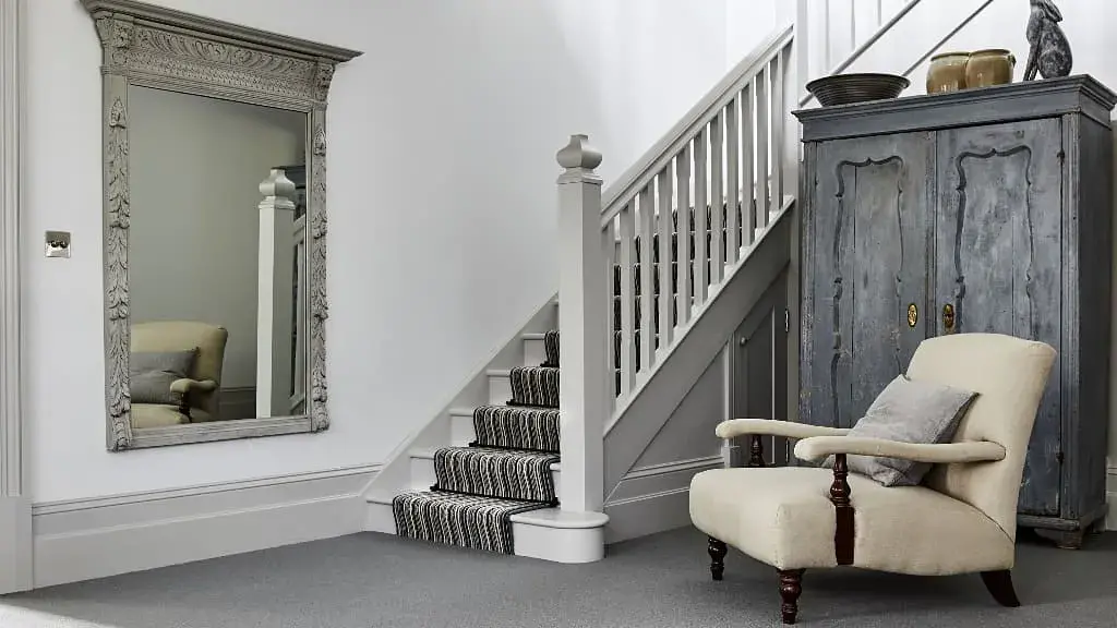 A chair and a mirror in a room : 
hallway design idea