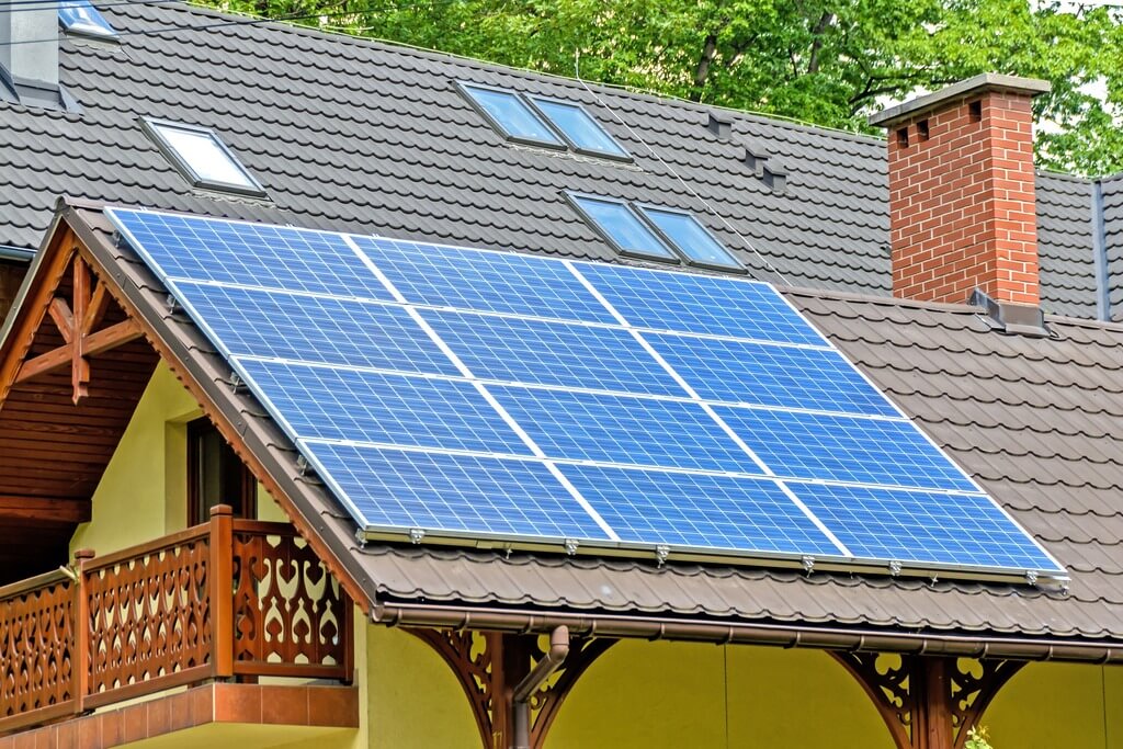 A house with a solar panel on the roof with chimney