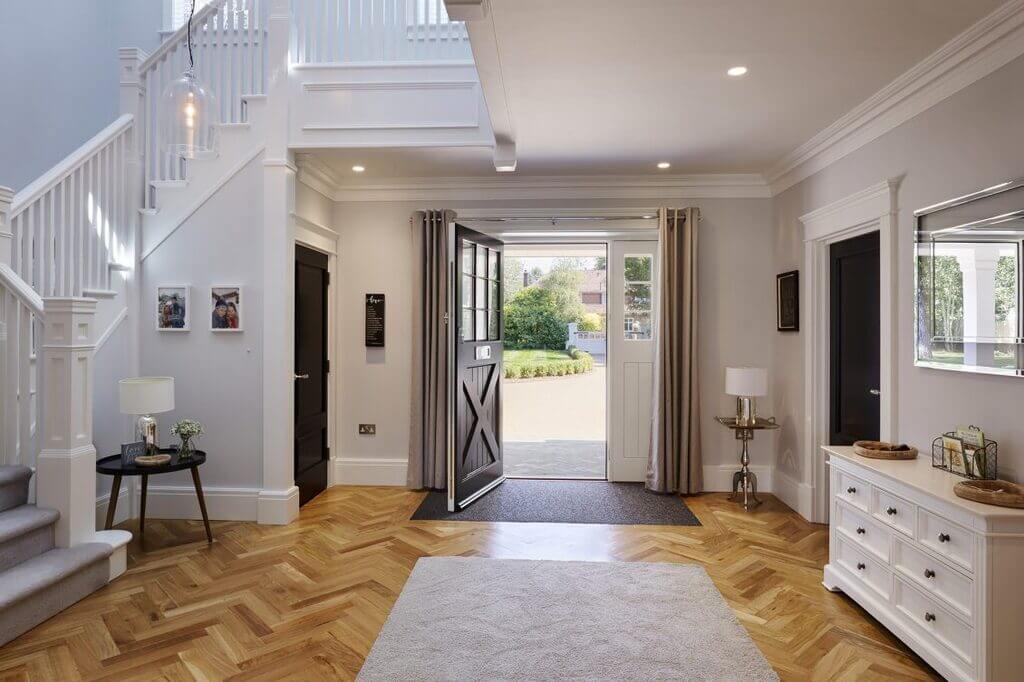 A large foyer with a white staircase and Skirting Boards floors
