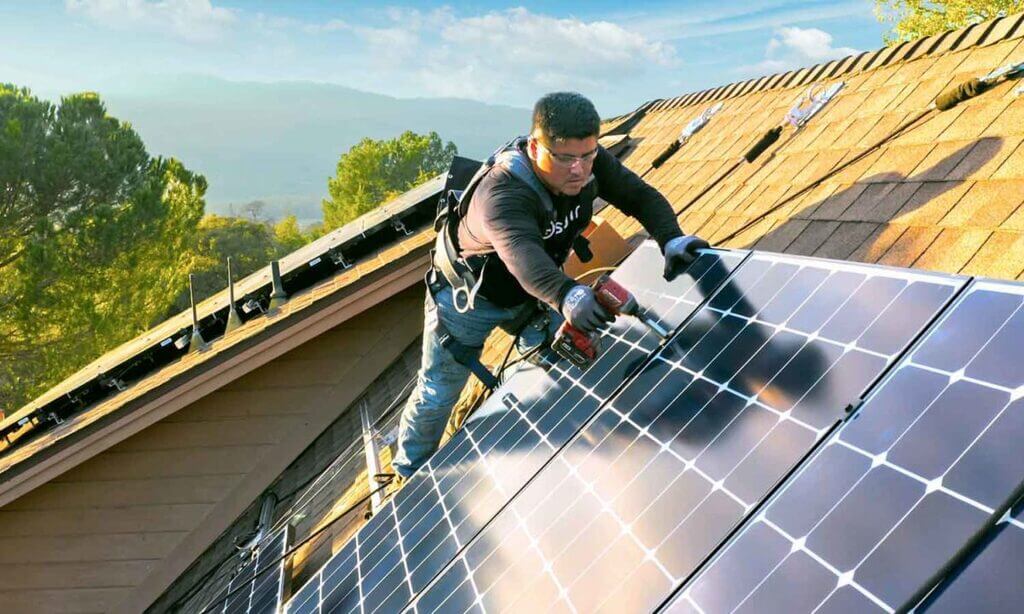 A technician  working on a solar panel on a roof