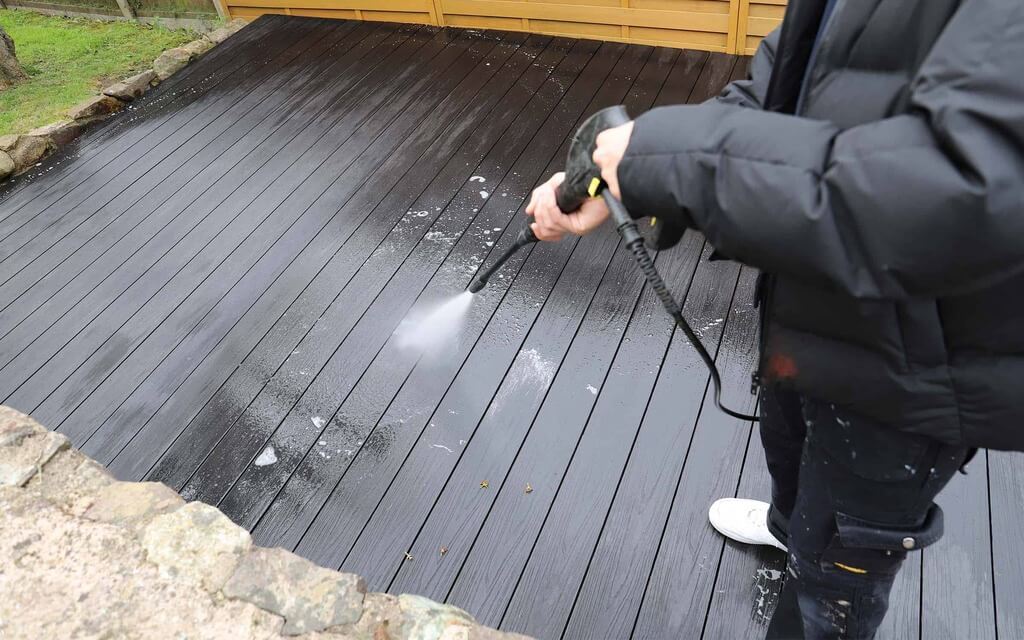 A person using a power tool on a deck
