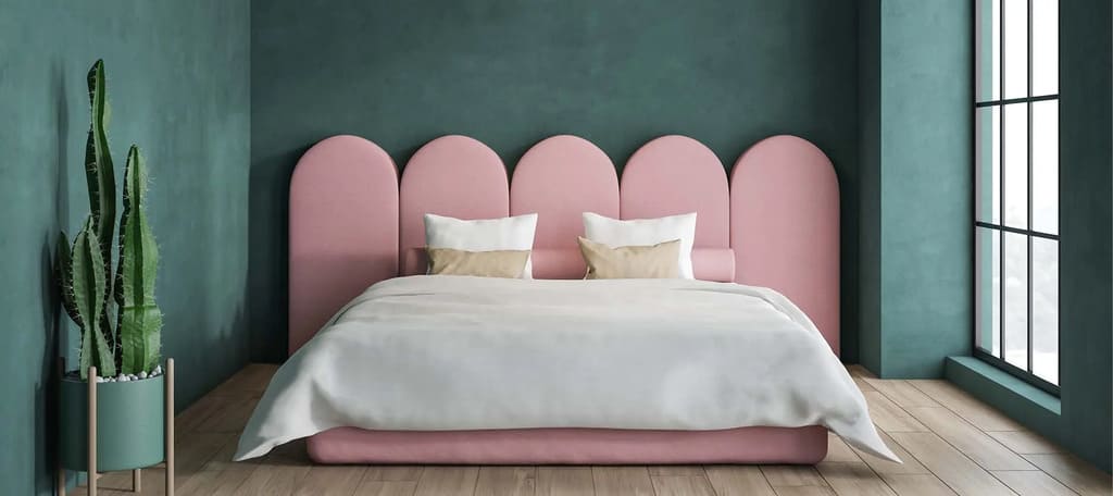 A bedroom with green walls and a pink bed
