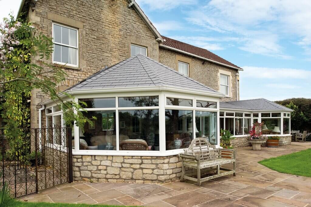 A house with a large conservatory in front of it.