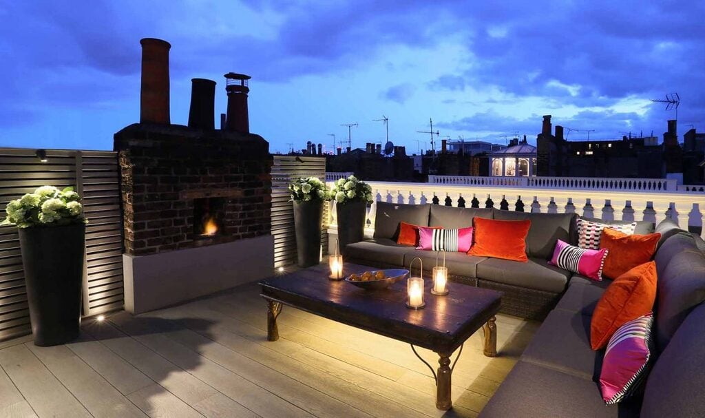 A rooftop area with a couch and a fire place
