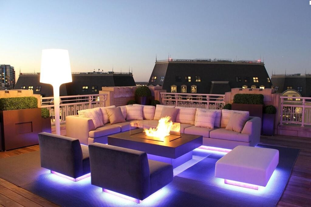 A rooftop with a couch and a fire pit
