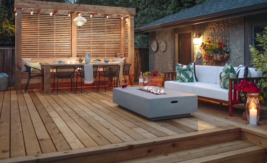 A deck with a couch, table, chairs and a fire pit

