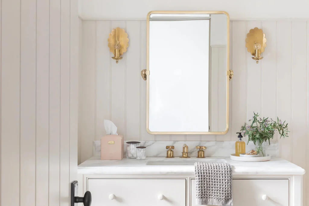 A bathroom vanity with a large mirror above it
