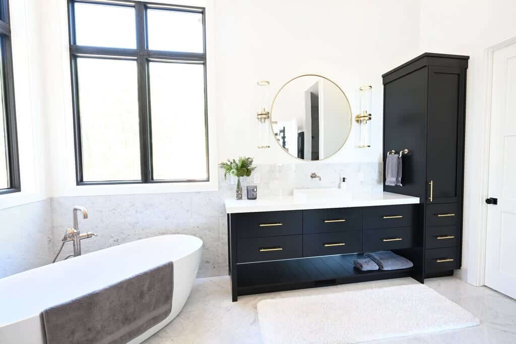 A bathroom with a tub, sink, and mirror
