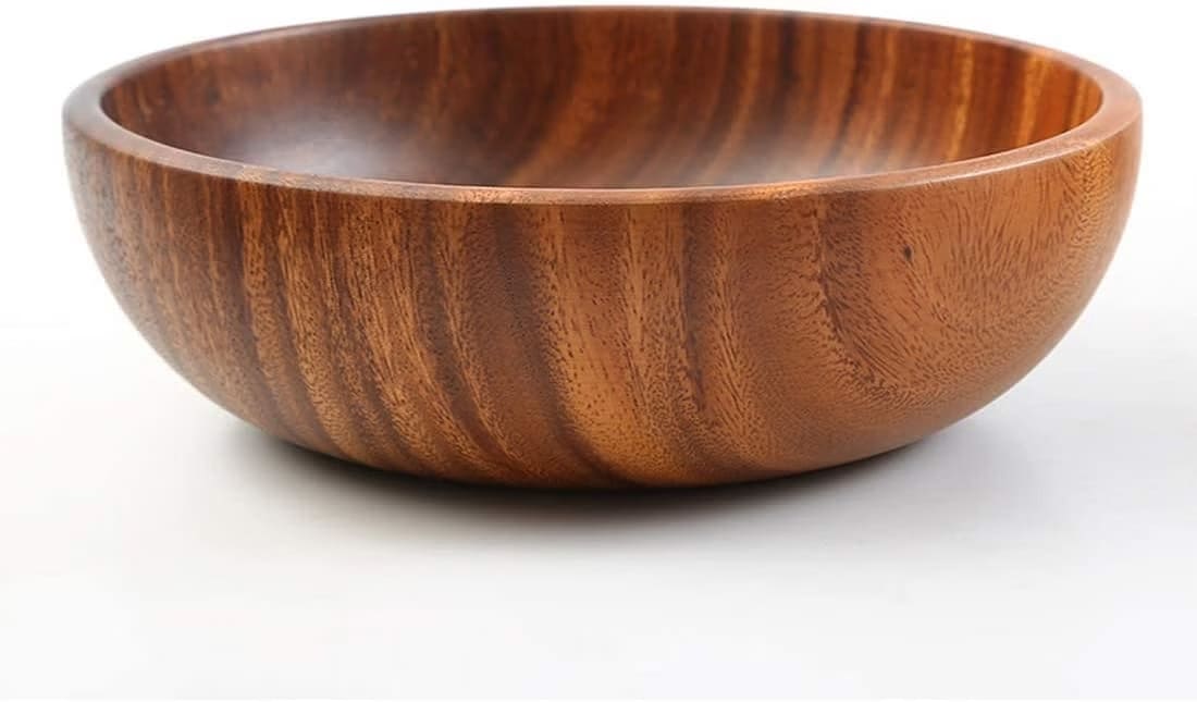 A wooden bowl sitting on top of a white table
